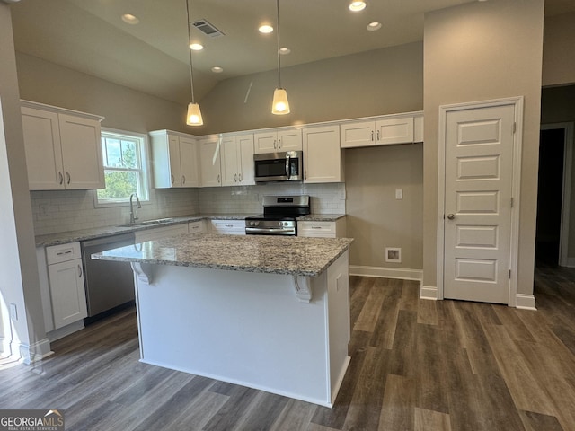 kitchen featuring dark wood-style flooring, a sink, stainless steel appliances, white cabinetry, and visible vents