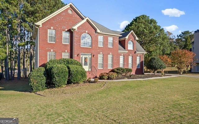 colonial home with a front lawn and brick siding