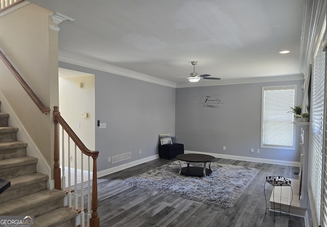 sitting room with wood finished floors, visible vents, baseboards, ceiling fan, and stairs