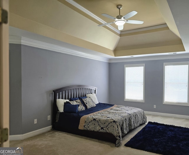 bedroom featuring a tray ceiling, crown molding, carpet, and a ceiling fan