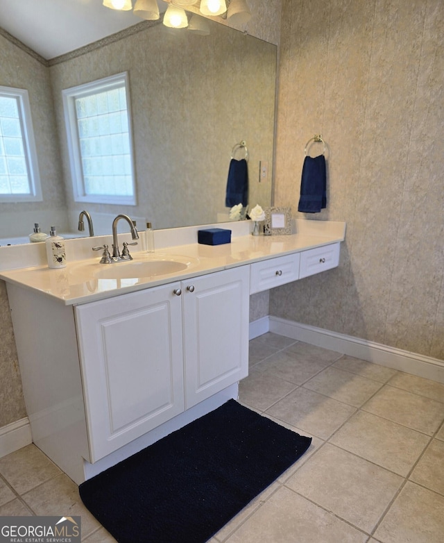 bathroom featuring baseboards, tile patterned flooring, vanity, and wallpapered walls