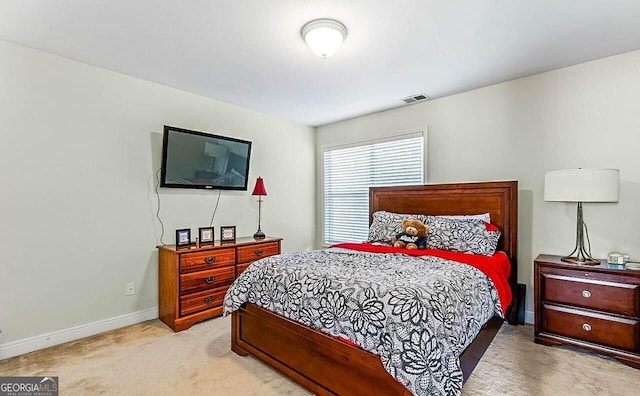 bedroom featuring baseboards, light carpet, and visible vents