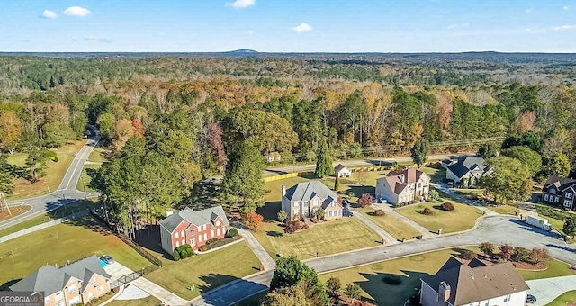 drone / aerial view featuring a forest view and a residential view
