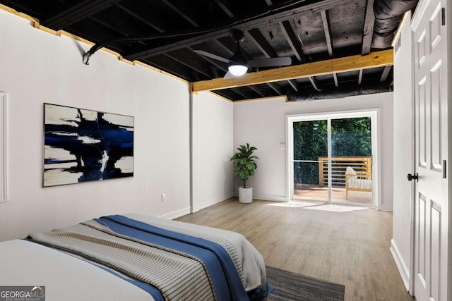 bedroom featuring access to outside, baseboards, and wood finished floors