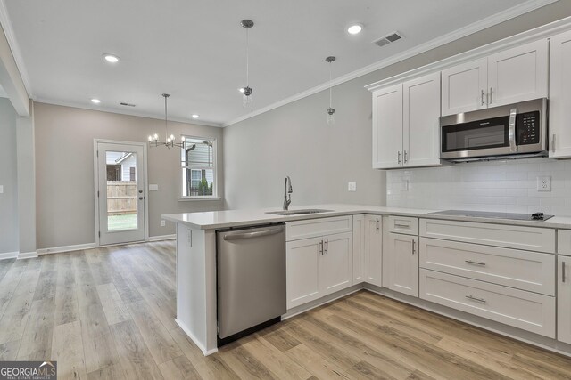 51 Camden Cir, Newnan, GA 30265 - kitchen featuring light countertops, white cabinets, a sink, backsplash, and stainless steel appliances