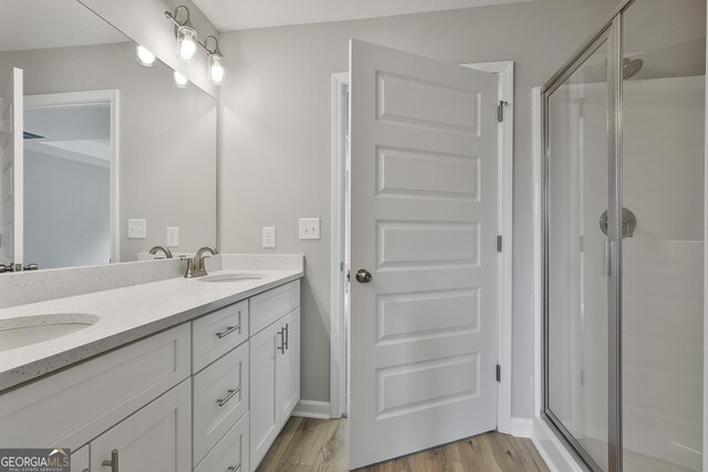 51 Camden Cir, Newnan, GA 30265 - full bath with double vanity, a shower stall, a sink, and wood finished floors