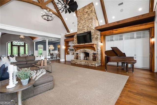 1101 N Flat Rock Rd, Douglasville, GA 30134 - living area with a notable chandelier, high vaulted ceiling, a stone fireplace, wood finished floors, and visible vents