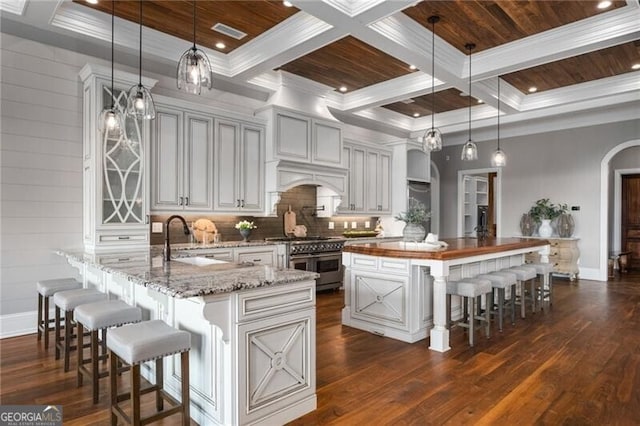 1101 N Flat Rock Rd, Douglasville, GA 30134 - kitchen with a sink, arched walkways, range with two ovens, baseboards, and a kitchen bar