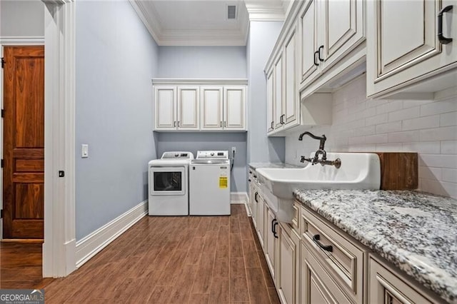 1101 N Flat Rock Rd, Douglasville, GA 30134 - washroom with crown molding, visible vents, washer and dryer, dark wood finished floors, and cabinet space