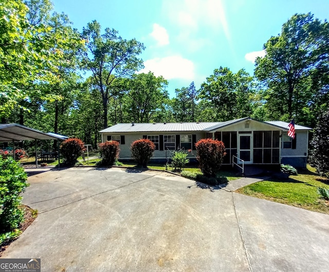 328 Kelly Creek Rd, Waco, GA 30182 - view of front of home featuring a carport, concrete driveway, a sunroom, metal roof, and a front lawn