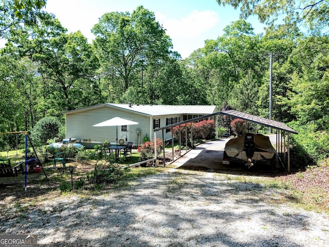 328 Kelly Creek Rd, Waco, GA 30182 - view of front facade with gravel driveway, metal roof, and a detached carport