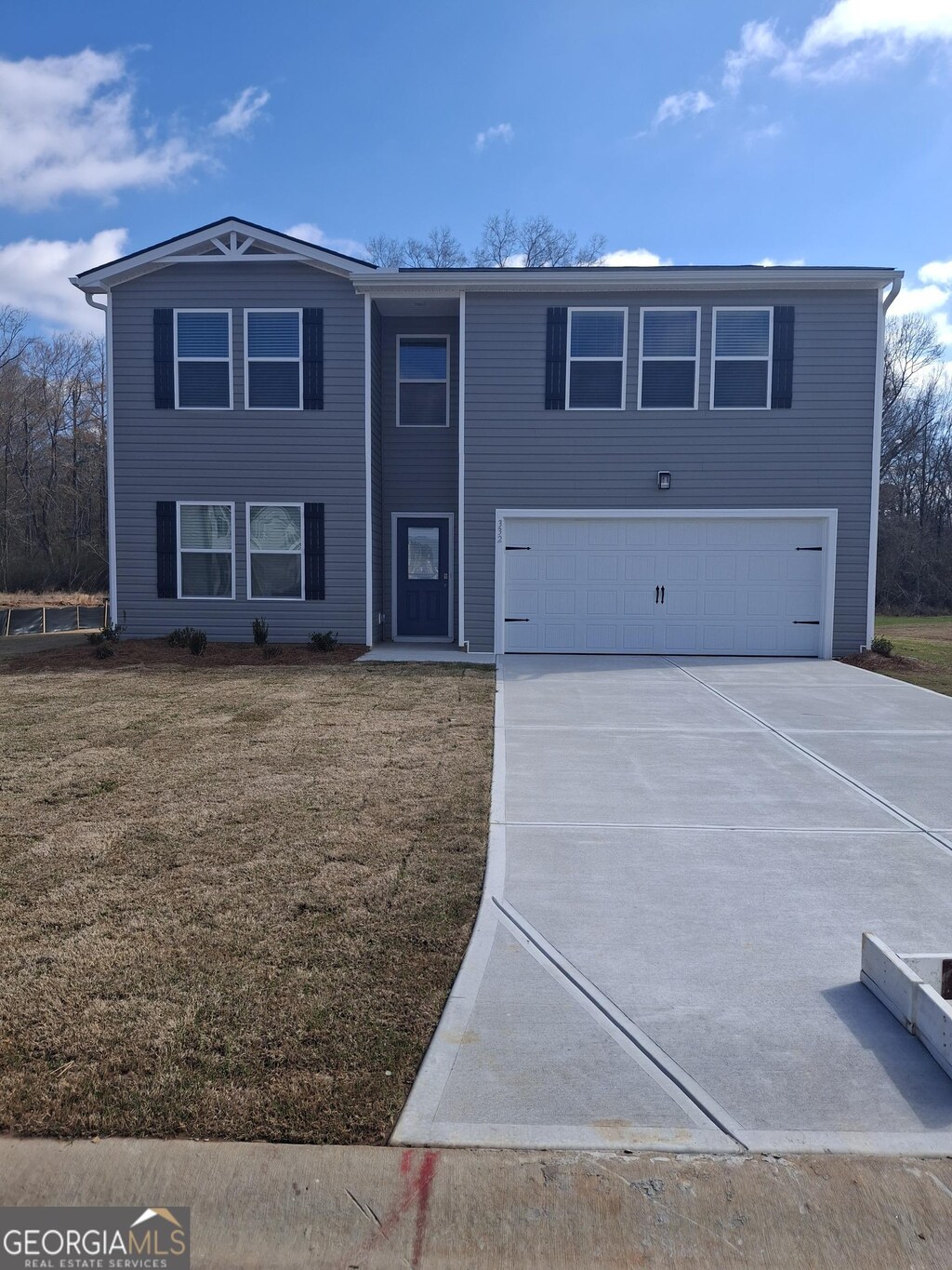 view of front facade with an attached garage, driveway, and a front lawn