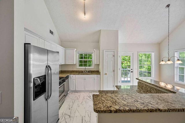kitchen with white cabinets, appliances with stainless steel finishes, a sink, a textured ceiling, and marble finish floor