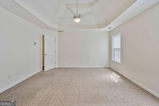unfurnished room featuring carpet floors, ceiling fan, baseboards, and a raised ceiling