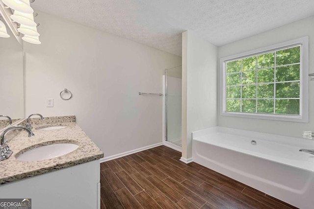 bathroom featuring baseboards, a sink, a bath, and wood finished floors