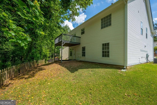 back of property featuring fence, a wooden deck, a lawn, and central air condition unit