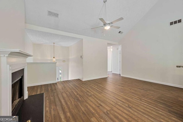 unfurnished living room featuring visible vents, ceiling fan, wood finished floors, and high vaulted ceiling