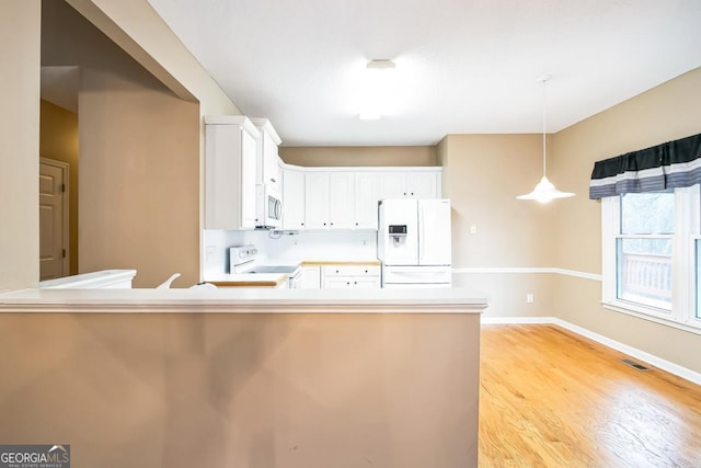 1008 Walnut Creek Dr, Woodstock, GA 30188 - kitchen featuring visible vents, white appliances, white cabinets, light wood finished floors, and decorative light fixtures