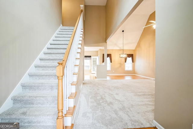 1008 Walnut Creek Dr, Woodstock, GA 30188 - staircase with carpet floors, baseboards, an inviting chandelier, and a towering ceiling