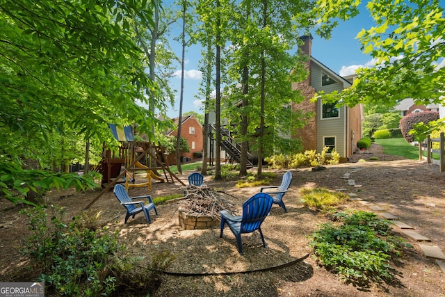 view of yard with a playground and an outdoor fire pit