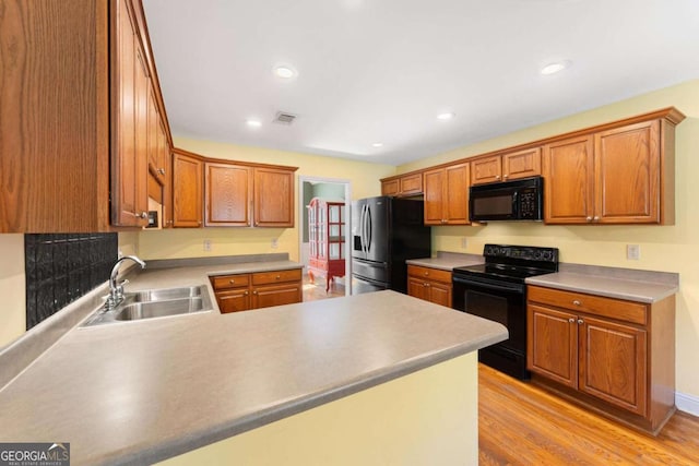 4572 Mulberry Fields Ln, Auburn, GA 30011 - kitchen featuring visible vents, a sink, black appliances, light wood finished floors, and a peninsula