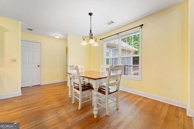 4572 Mulberry Fields Ln, Auburn, GA 30011 - dining room featuring a chandelier, baseboards, visible vents, and light wood-style flooring