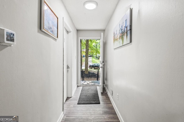 hallway featuring baseboards and wood finished floors