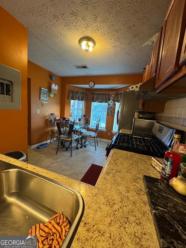6444 Charter Way, Lithonia, GA 30058 - kitchen featuring stainless steel gas range oven, a sink, light countertops, visible vents, and electric panel