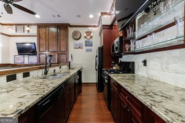 kitchen featuring backsplash, light stone counters, a sink, and black appliances
