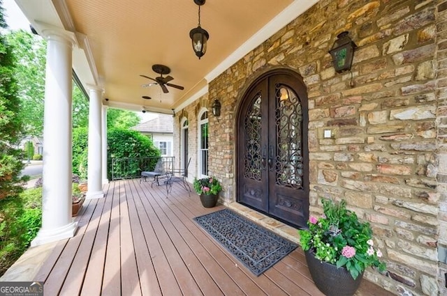 entrance to property with covered porch, french doors, and stone siding