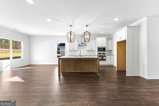 kitchen featuring built in microwave, recessed lighting, wall chimney exhaust hood, and oven