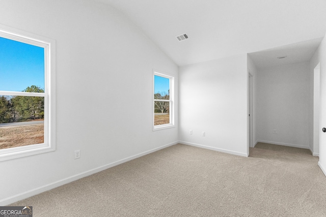 unfurnished bedroom featuring multiple windows, light colored carpet, and visible vents