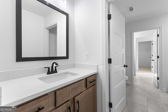bathroom featuring vanity, tile patterned floors, visible vents, and toilet