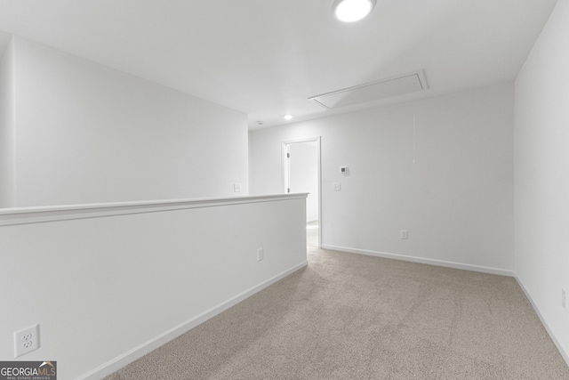 unfurnished room featuring carpet floors, recessed lighting, baseboards, and attic access