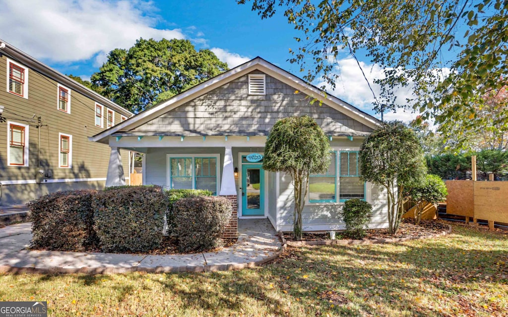 bungalow-style home with a front yard