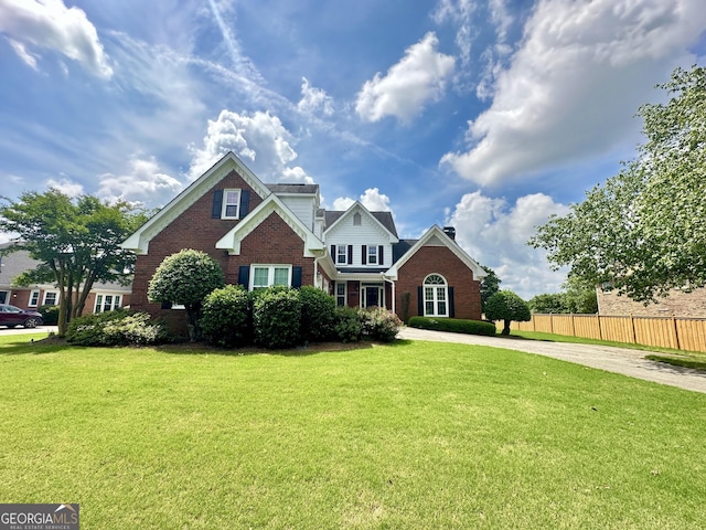 23 Saint Ives Ln, Winder, GA 30680 - view of front facade with brick siding, fence, driveway, and a front yard