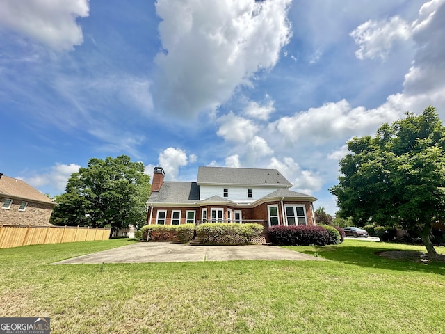 23 Saint Ives Ln, Winder, GA 30680 - back of property with a lawn, brick siding, fence, and a chimney