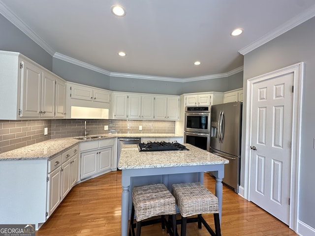 23 Saint Ives Ln, Winder, GA 30680 - kitchen featuring a sink, a kitchen island, ornamental molding, and stainless steel appliances