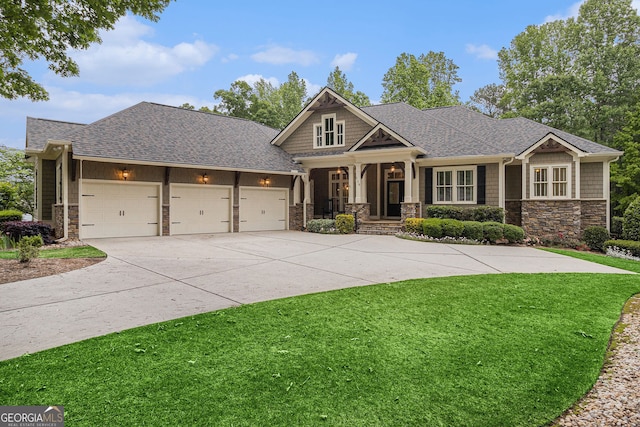 craftsman-style house with stone siding, a garage, a porch, a front yard, and concrete driveway