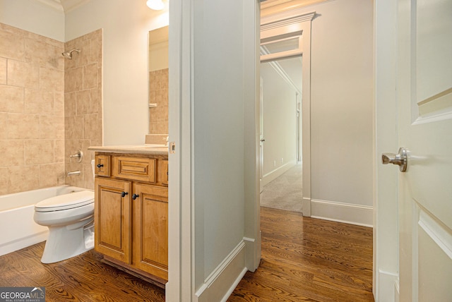 full bathroom with shower / tub combination, vanity, toilet, wood finished floors, and ornamental molding