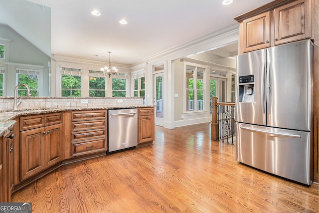kitchen featuring stainless steel appliances, plenty of natural light, a sink, and tasteful backsplash