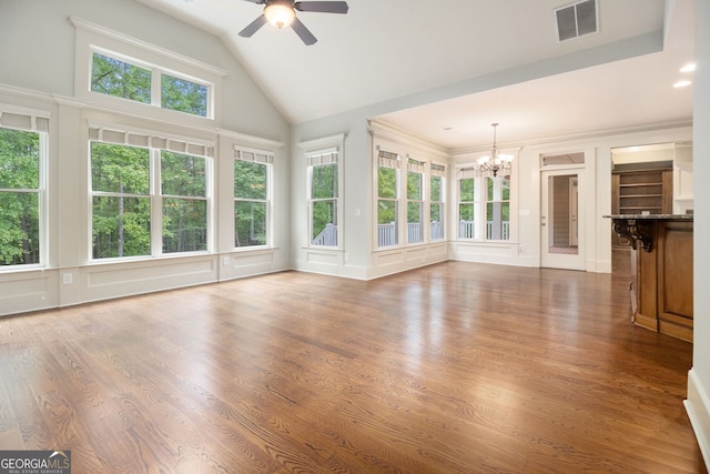 unfurnished living room with high vaulted ceiling, ceiling fan with notable chandelier, a decorative wall, and visible vents