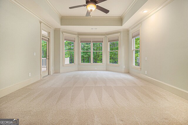 empty room featuring baseboards, ornamental molding, carpet, and a ceiling fan