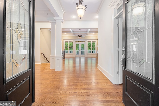 foyer entrance with beamed ceiling, decorative columns, ornamental molding, and light wood finished floors
