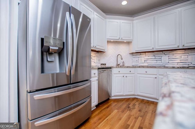 213 Shady Valley Dr, Carrollton, GA 30116 - kitchen featuring stainless steel appliances, white cabinets, light wood-type flooring, decorative backsplash, and light stone countertops