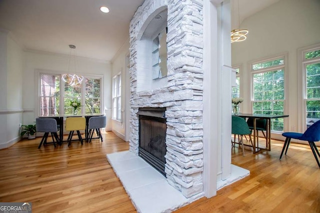 213 Shady Valley Dr, Carrollton, GA 30116 - living room featuring a chandelier, light wood-style floors, plenty of natural light, a fireplace, and crown molding