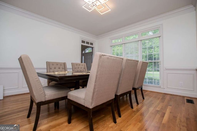 213 Shady Valley Dr, Carrollton, GA 30116 - dining room with crown molding, a decorative wall, healthy amount of natural light, light wood-type flooring, and wainscoting