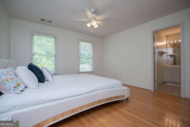 213 Shady Valley Dr, Carrollton, GA 30116 - bedroom with light wood finished floors, multiple windows, ceiling fan, and ensuite bath