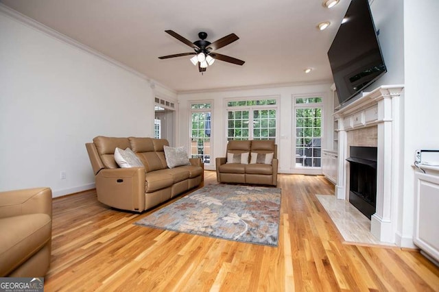 213 Shady Valley Dr, Carrollton, GA 30116 - living area featuring crown molding, a ceiling fan, light wood finished floors, plenty of natural light, and a fireplace with flush hearth