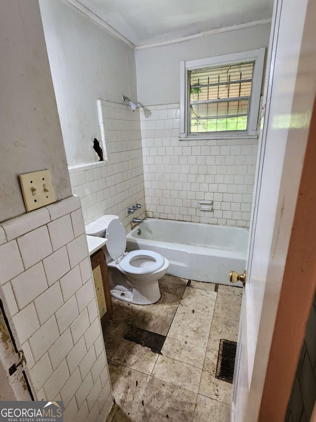 bathroom featuring vanity, toilet, tile walls,  shower combination, and visible vents
